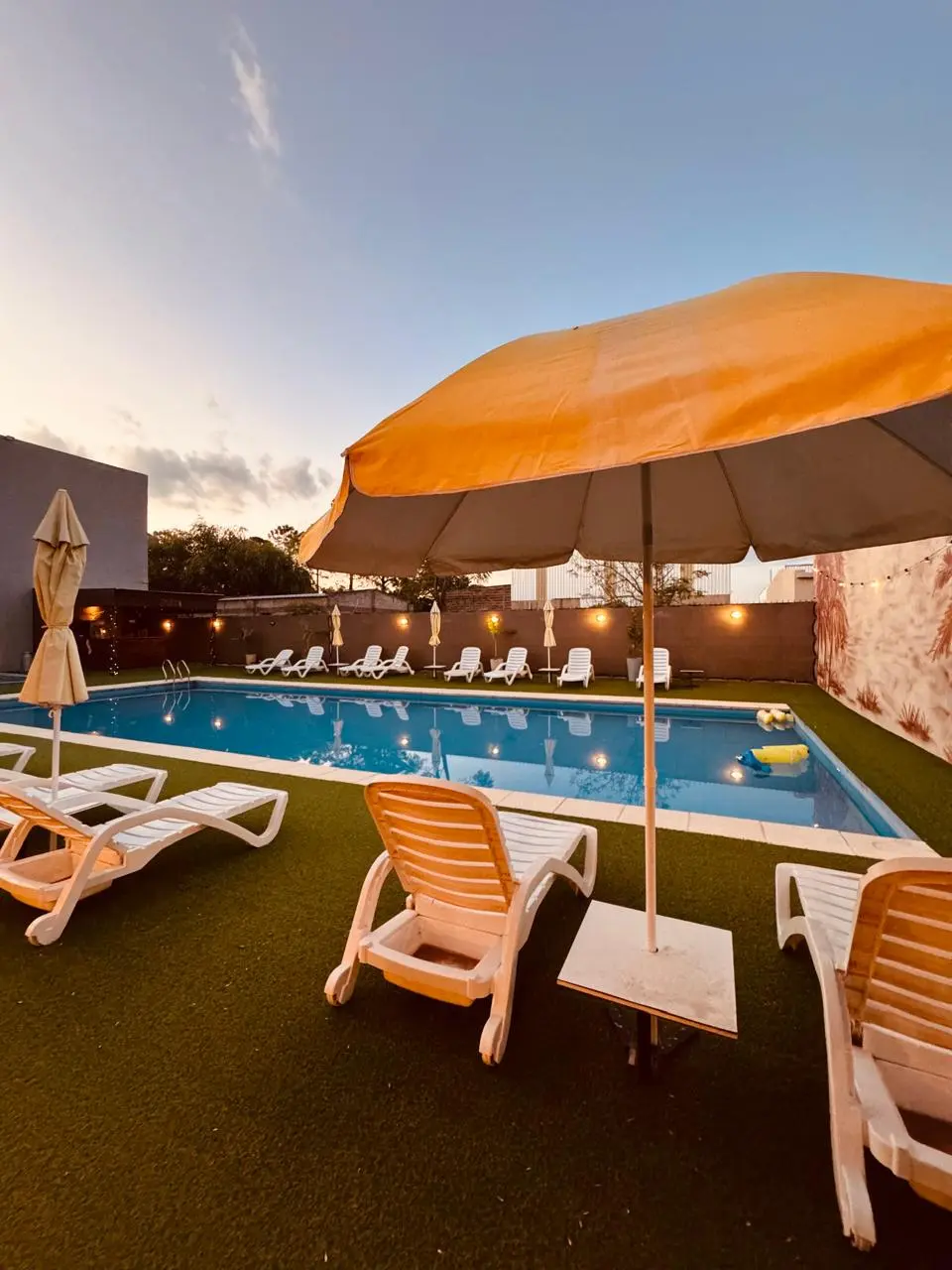Piscina al atardecer con sombrilla abierta
